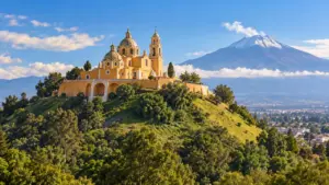 Ilustración de Cholula con el santuario sobre la Gran Pirámide y un volcán al fondo